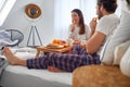 A young couple eating delicious oranges during a breakfast in the bed. Love, relationship, together Royalty Free Stock Photo