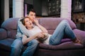 Young couple eating popcorn and watching a movie at home on the couch, scared. Royalty Free Stock Photo