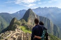Young couple embracing contemplating the incredible landscape of Machu Picchu.
