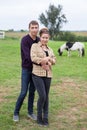 Young couple embracing in farmland, portrait of young man nand woman in countryside, horse is on background Royalty Free Stock Photo