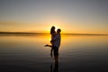 Young couple is embracing in the water on summer beach. Sunset over the sea.Two silhouettes against the sun. Just married couple Royalty Free Stock Photo