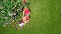 Young couple enjoying food and drinks in beautiful roses garden on romantic date, aerial top view from above of man and woman Royalty Free Stock Photo