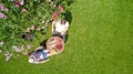 Young couple enjoying food and drinks in beautiful roses garden on romantic date, aerial top view from above of man and woman Royalty Free Stock Photo