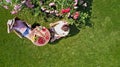 Young couple enjoying food and drinks in beautiful roses garden on romantic date, aerial top view from above Royalty Free Stock Photo