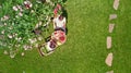 Young couple enjoying food and drinks in beautiful roses garden on romantic date, aerial top view from above of man and woman Royalty Free Stock Photo