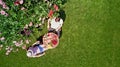 Young couple enjoying food and drinks in beautiful roses garden on romantic date, aerial top view from above of man and woman Royalty Free Stock Photo