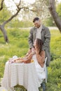 Young couple enjoying food and drinks in beautiful summer green park on romantic date picnic, handsome man and woman Royalty Free Stock Photo