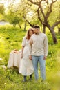 Young couple enjoying food and drinks in beautiful summer green park on romantic date picnic, handsome man and woman Royalty Free Stock Photo