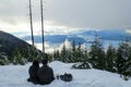 A young couple enjoying the gorgeous winter landscape on Cypress Mountain overlooking the ocean below on the Bowen Island Lookout. Royalty Free Stock Photo