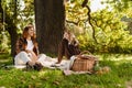 Young couple enjoying picnic time while sitting under the tree in park