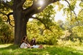 Young couple enjoying picnic time while sitting under the tree in park