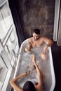 Couple enjoying and relaxing in the bathtub and drinking champagne top view Royalty Free Stock Photo