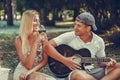 Beautiful couple having fun with guitar during picnic in the park Royalty Free Stock Photo