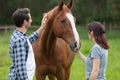 young couple enjoys spending time with horses Royalty Free Stock Photo