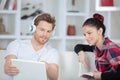 young couple entertaining themselves with book and laptop Royalty Free Stock Photo