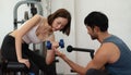 Young couple exercising in a gym When lifting weights, they assist one another Royalty Free Stock Photo