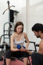 Young couple exercising in a gym When lifting weights, they assist one another Royalty Free Stock Photo