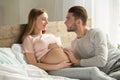 Young couple expecting baby relax on bed indoors Royalty Free Stock Photo