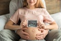 Young couple expecting baby relax on bed indoors Royalty Free Stock Photo