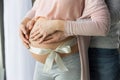 Young couple expecting baby standing together indoors