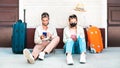 Young couple with face mask using mobile smart phones - Young people checking online reservations sitting on floor Royalty Free Stock Photo