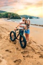 Couple with fat bike taking a selfie with their dog on the beach Royalty Free Stock Photo