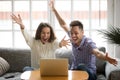 Young couple feeling excited by online win looking at laptop Royalty Free Stock Photo