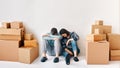 Young couple fell asleep after a moving day sitting on the floor surrounded by cardboard boxes Royalty Free Stock Photo