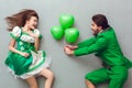 Young couple in festive costumes saint patrick`s day top view giving present
