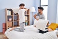 Young couple fighting with pillow on bed at bedrooom