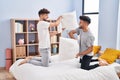 Young couple fighting with pillow on bed at bedrooom