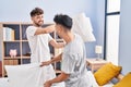 Young couple fighting with pillow on bed at bedrooom