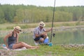 Young couple fishing or angling on lake shore Royalty Free Stock Photo