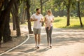 Young Couple Fitness In Sportswear Running Together In Park . Sport Man And Woman Jogging Outdoors In Nature. Workout ,exercising