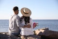 Couple with flowers at beach. Honeymoon trip