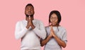 Young couple folded their hands, praying with closed eyes