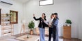 Young couple follow a real estate agent who is giving them a tour around a home, showing all the room and telling about Royalty Free Stock Photo