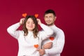 Young couple fooling around and having fun on St.Valentine`s Day. Red background and empty space Royalty Free Stock Photo