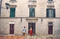 Young couple in front of old European building, going on date. Walk in city. Beautiful woman in red summer dress, stylish handsome Royalty Free Stock Photo