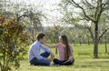 Young couple in german green landscape with trees and bushes, the girlfriend is stroking the boyfriend the cheek