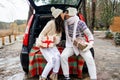Young couple giving presents and kissing in the trunk in winter holidays. Royalty Free Stock Photo