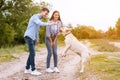 Young couple giving a treat to their happy dog