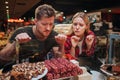 Young couple in grocery store. They look at sweets with hunger and devotion. Tasty delicious sweets.