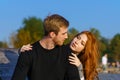 young couple are sitting in the park on a wooden bench hugging Royalty Free Stock Photo