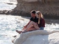 Young couple, a guy and a girl, sit on a rock, on the shores of the Mediterranean sea, and look out to sea in Nahatiya, Israel Royalty Free Stock Photo