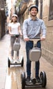 young couple guy and girl walking on segway in streets of european city Royalty Free Stock Photo