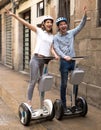 Young couple guy and girl walking on segway in streets of european city Royalty Free Stock Photo