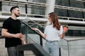 young couple handsome brunette man drinks coffee with his beautiful woman on the street, having vivid conversation Royalty Free Stock Photo