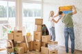 Moving house. Couple hanging picture on wall in new home Royalty Free Stock Photo