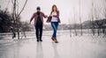 Young couple has fun during winter walk on ice of frozen lake. Royalty Free Stock Photo